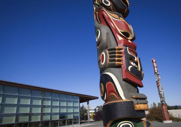 Totem pole with a building in the background